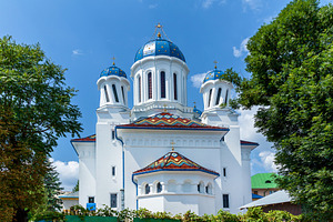 Orthodox church with blue domes and colorful roof tiles, an Architecture Photo by Photostock