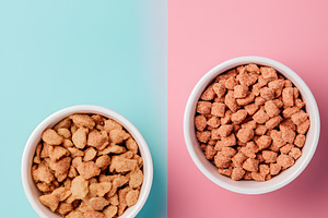 Cereal snacks in bowls on pastel background, a Food & Drink Photo by Photostock