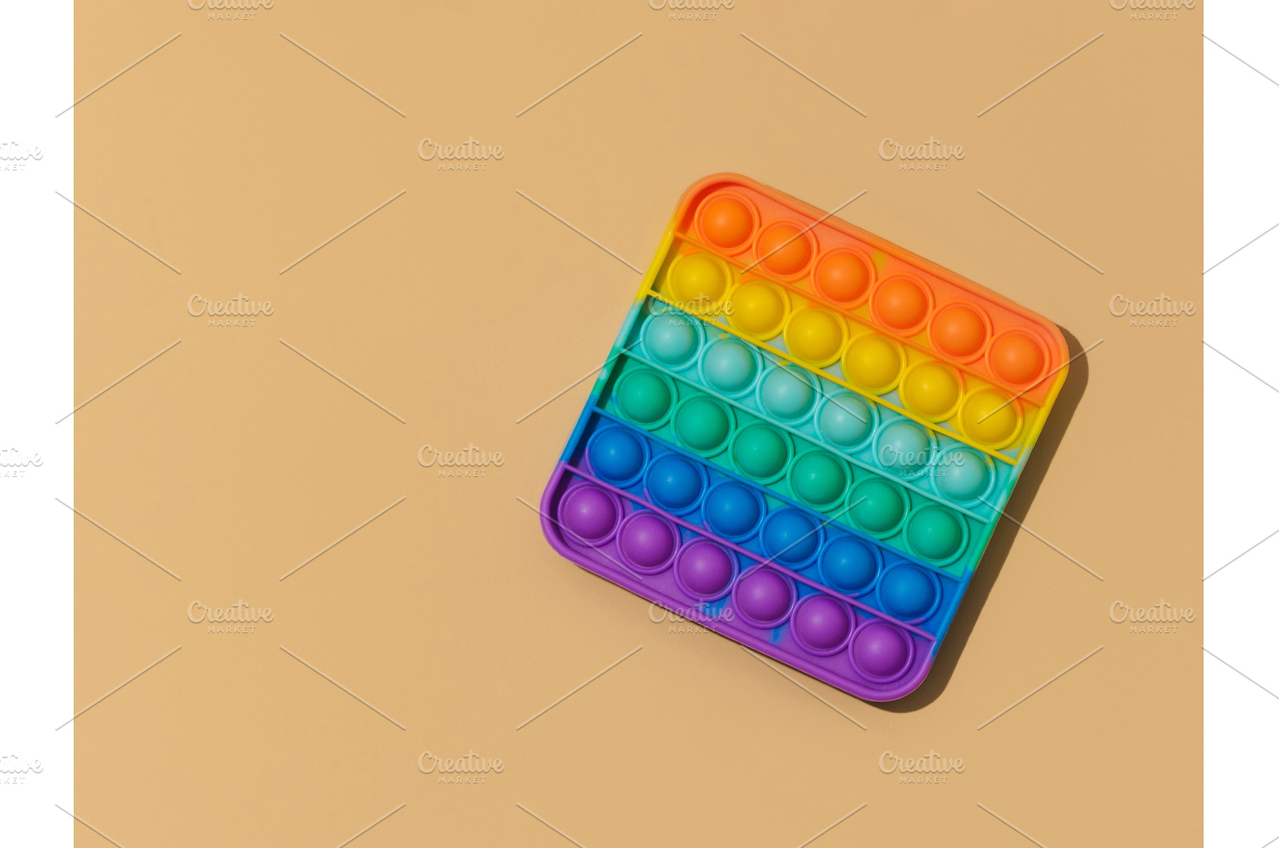Popit toy on pastel beige background, a School & Education Photo by Fascinadora