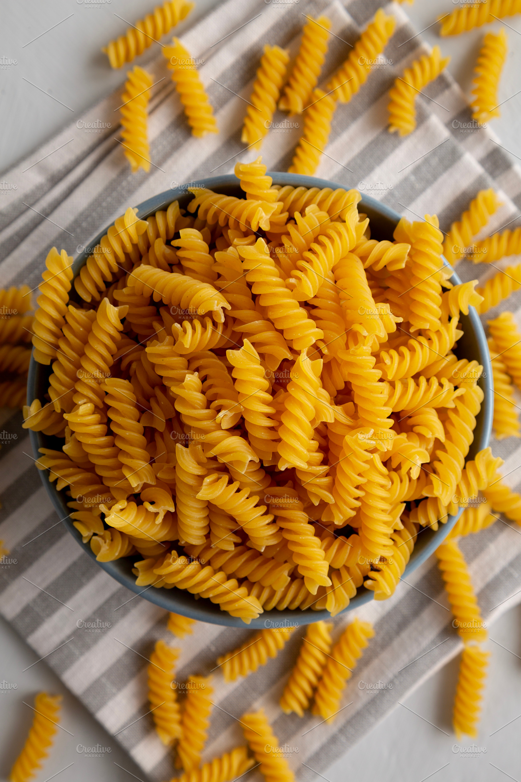 Dry Fusilli Pasta in a Bowl, top view. Flat lay, overhead, from, a Food & Drink Photo by LiudmylaChuhunova