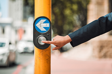 Woman, hands and arrow button on road in city for pedestrian crossing signal in safe travel outdoors. Female person touching sign, symbol or crosswalk by robot for safety on street in Cape Town, a Photo by Peopleimages.com