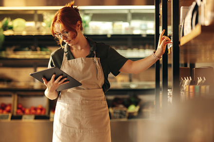 Supermarket owner using a digital tablet in her shop, a Person Photo by Jacob Lund