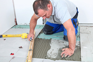 Man tile mason working inside a modern home, a Person Photo by DanFLCreativo