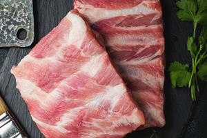 Raw meat. Raw pork ribs from the back with meat on a black background. backgrou, a Food & Drink Photo by Budarinphoto