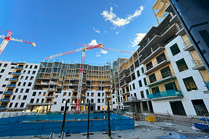 Construction site building cranes moving on a sunny day, an Industrial Photo by karrastock