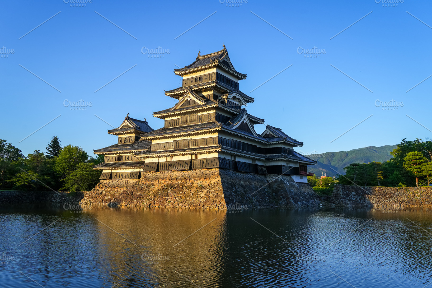 Matsumoto Castle reflecting in the water at sunset, Japan, an Architecture Photo by GoodGoods