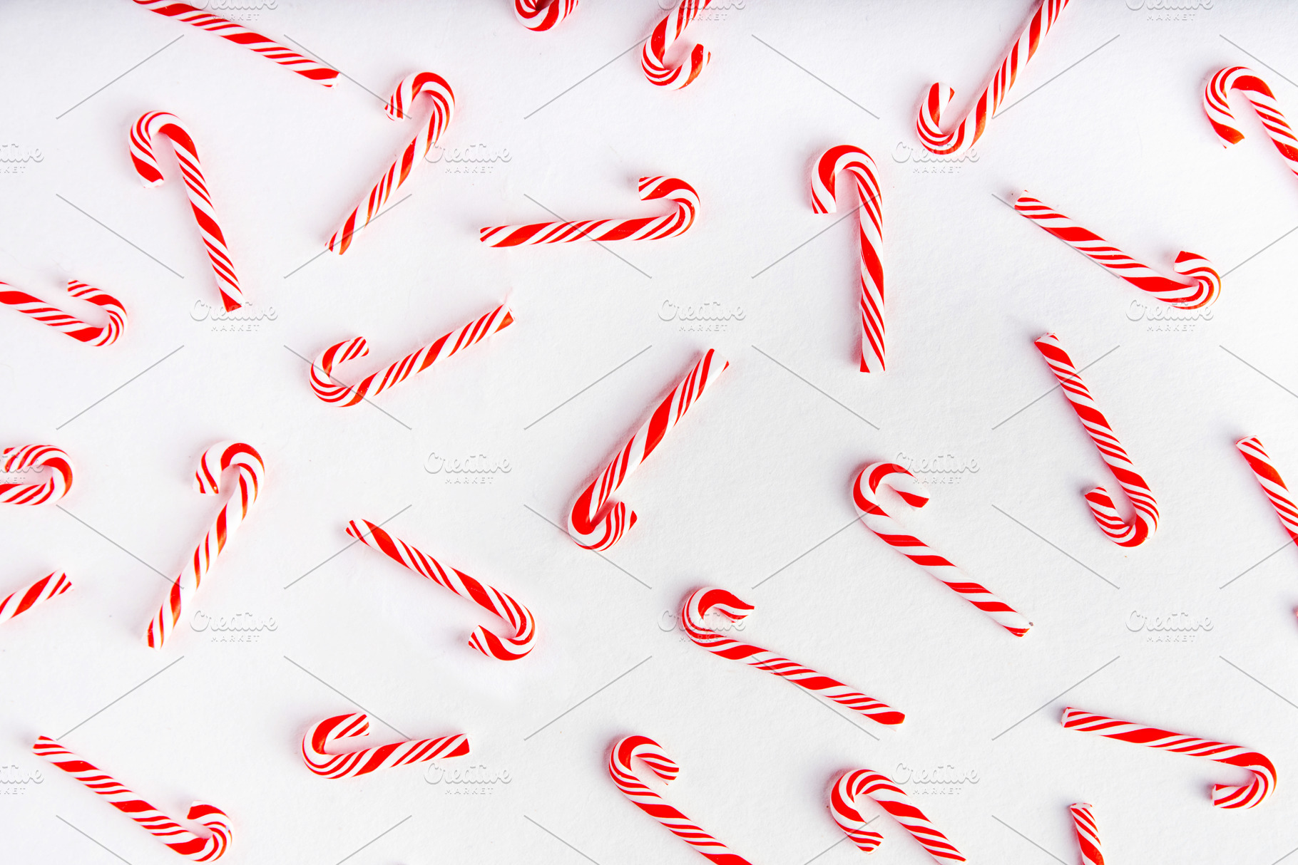 Candy cane sweets on white background, simple pattern, layout, a Holiday Photo by Rimma