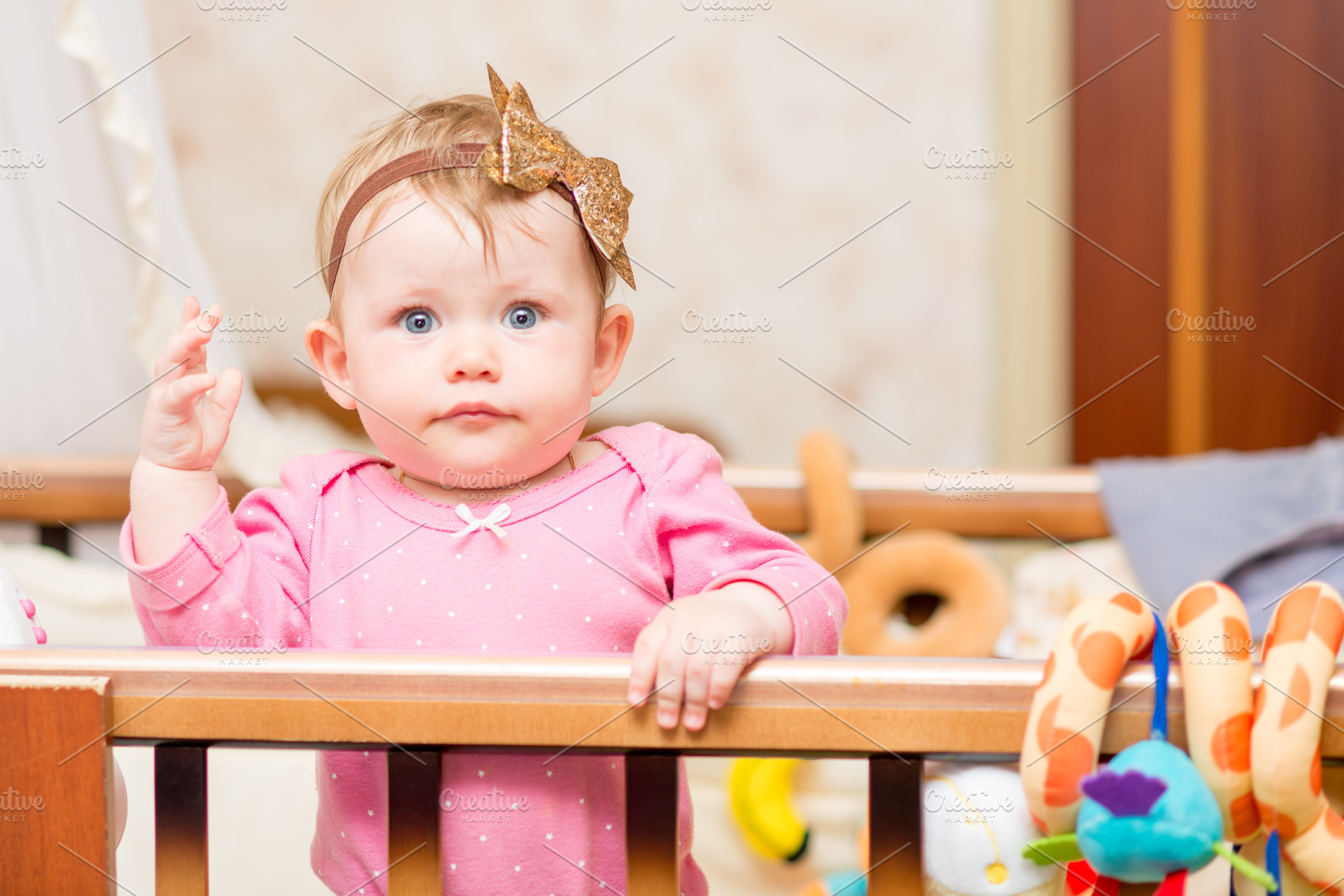 A baby in the crib looks at the camera featuring cute, childhood, and bed, a Person Photo by Evgeniy Losev