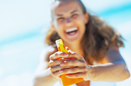 Closeup on young woman pointing bottle of sun block creme in cam, a Person Photo by Alliance Images