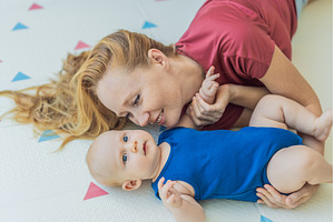 Mother and baby lying on a soft play, an Architecture Photo by Elizaveta Galitskaya
