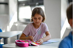 Cute schoolgirl is choosing a pen, a School & Education Photo by HalfPoint