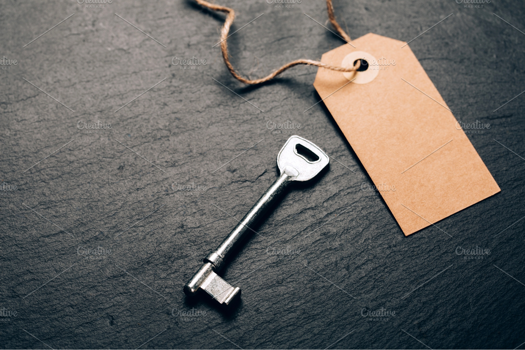 Key and blank kraft tag on slate, a Business Photo by Anna Efetova