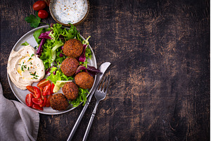 Salad with hummus, falafel and, a Food & Drink Photo by Yulia Furman
