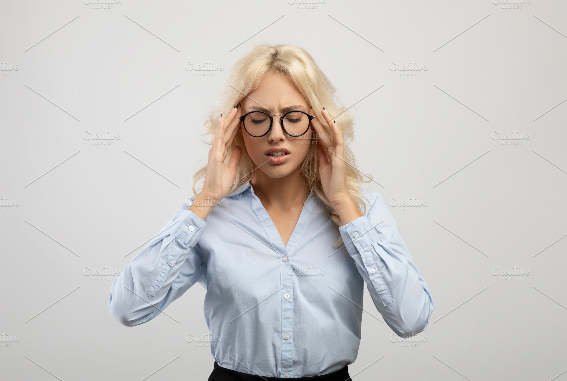 Young tired female entrepreneur suffering from headache and touching temples, s, a Photo by Prostock-Studio
