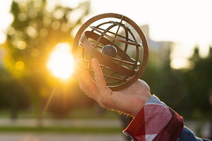 Hand holding antique metal globe, a School & Education Photo by Elena Vagengeim