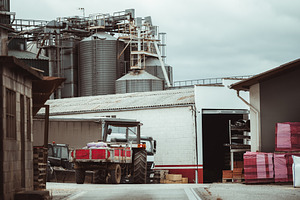 Tractor at grain silo facility, an Industrial Photo by SkyNext