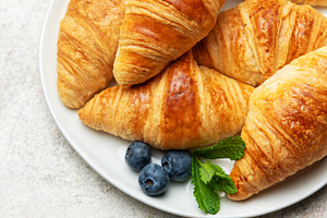 Freshly baked croissants with blueberries and mint on white plat, a Food & Drink Photo by Olena Rudo