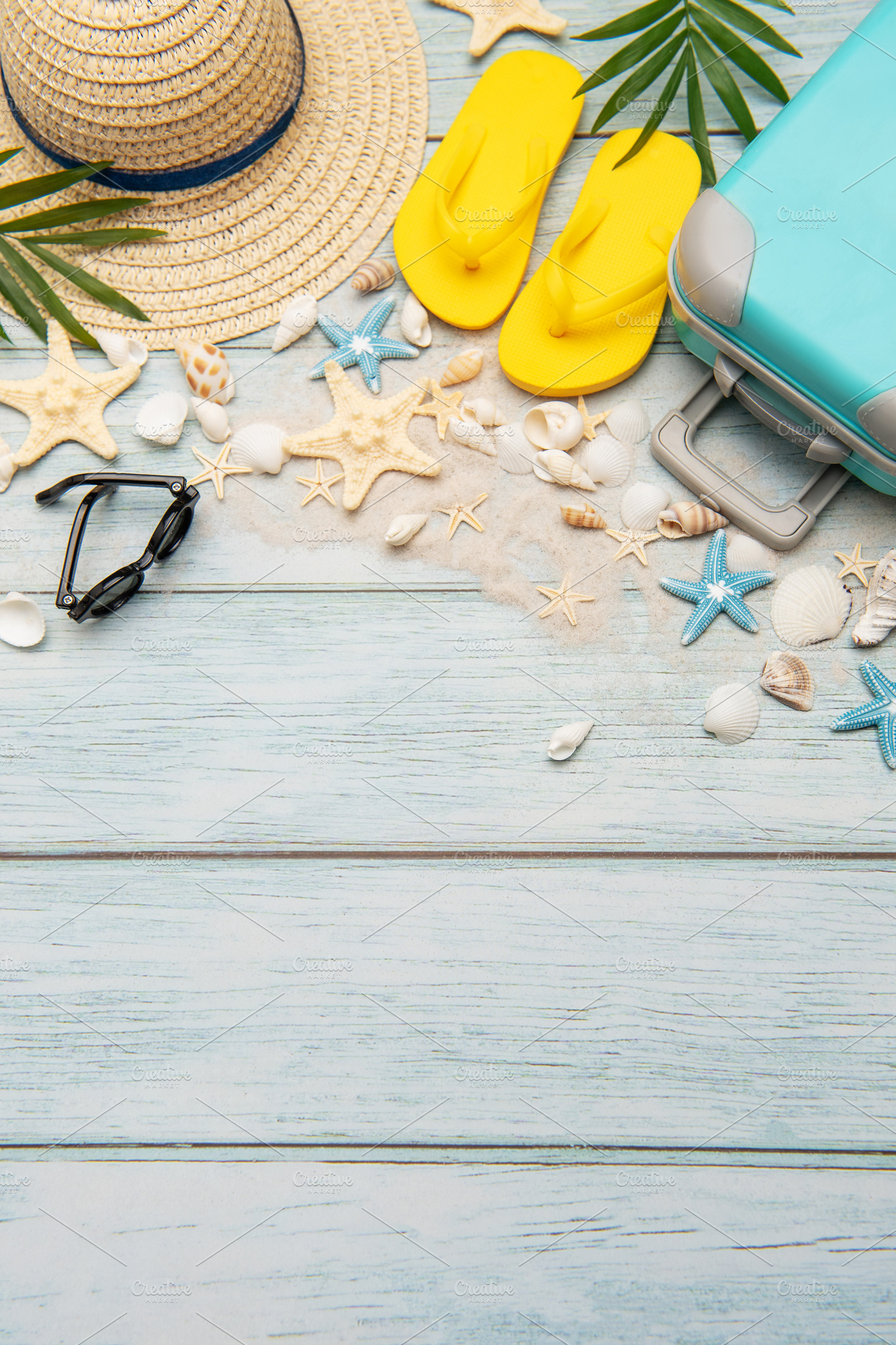 Summer accessories creating a frame on light blue wooden backgro, a Holiday Photo by Olena Rudo