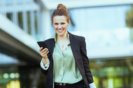 smiling 40 years old woman worker near office building walking, a Business Photo by Alliance Images