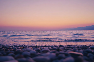 Stunning sunset over the calm sea with gentle waves and colorful sky, a Wallpaper Photo by AlyaAnd