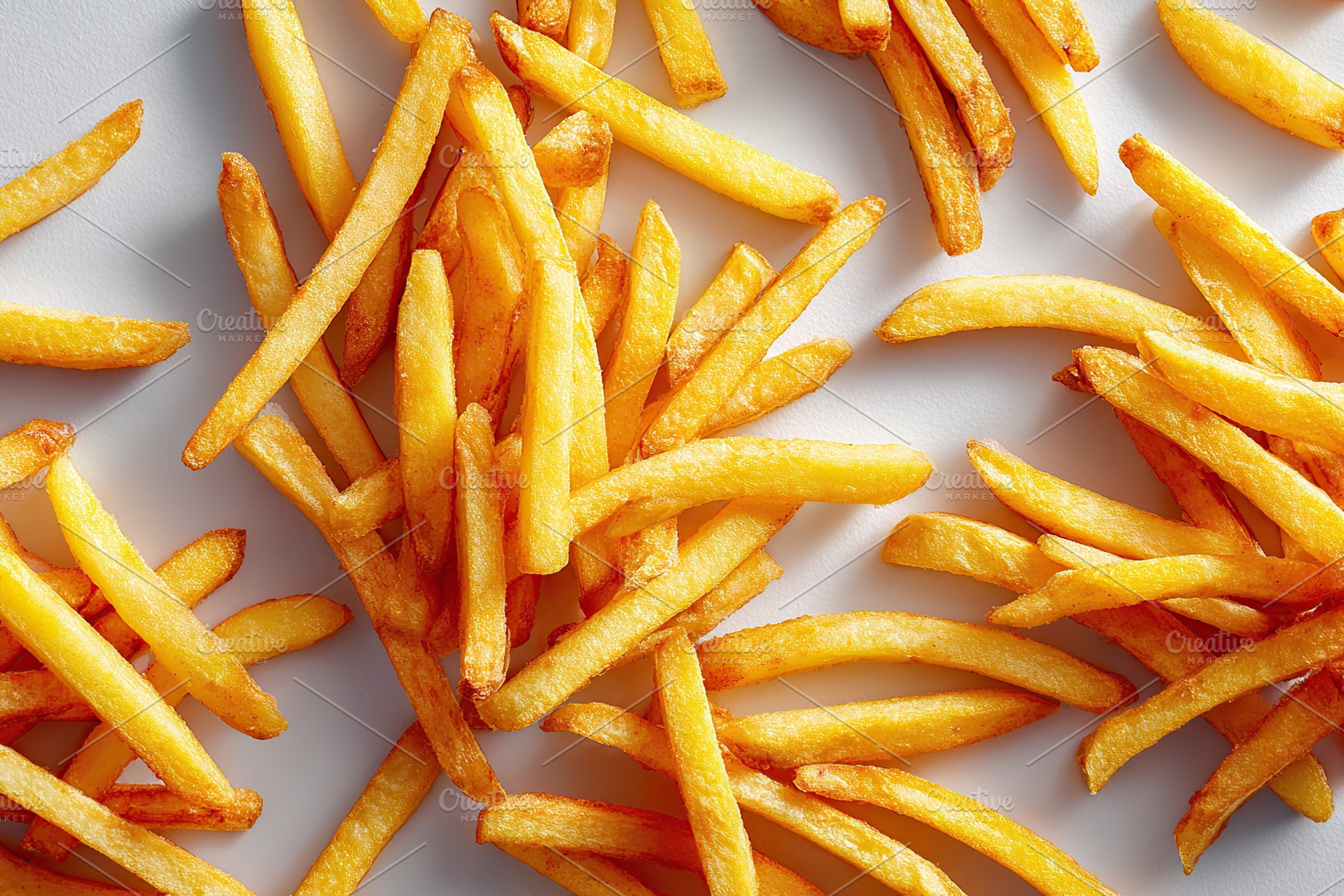 Delicious golden french fries arranged artfully on a neutral surface, a Food & Drink Photo by AlyaAnd
