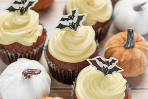 Halloween inviting celebration with themed cupcakes and pumpkins, a Food & Drink Photo by Olena Rudo