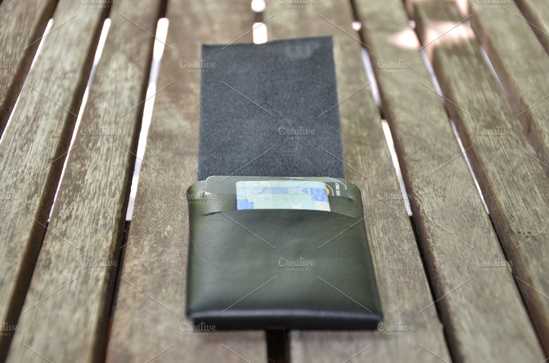 Leather wallet with money featuring leather, fashion, and design