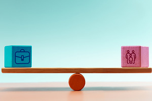 Blocks with work and family icons balanced on seesaw, symbolizin, a Photo by salmon.black