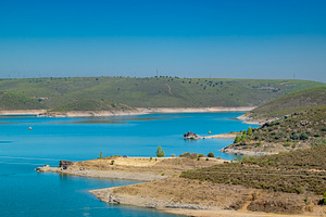 Lake surrounded by hills and arid landscape, a Nature Photo by DanFLCreativo