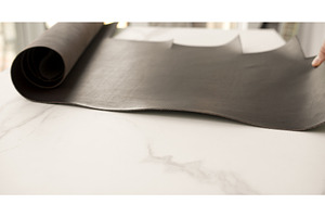 Roll of dark brown leather on white, an Industrial Photo by volodymyrshtun13795