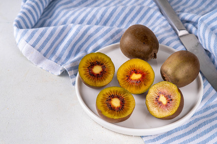 Red kiwi, Sweet bright red colored kiwi fruits, whole and sliced, a Food & Drink Photo by Rimma