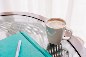A view of a coffee and a notebook featuring creative, feminine, and pink