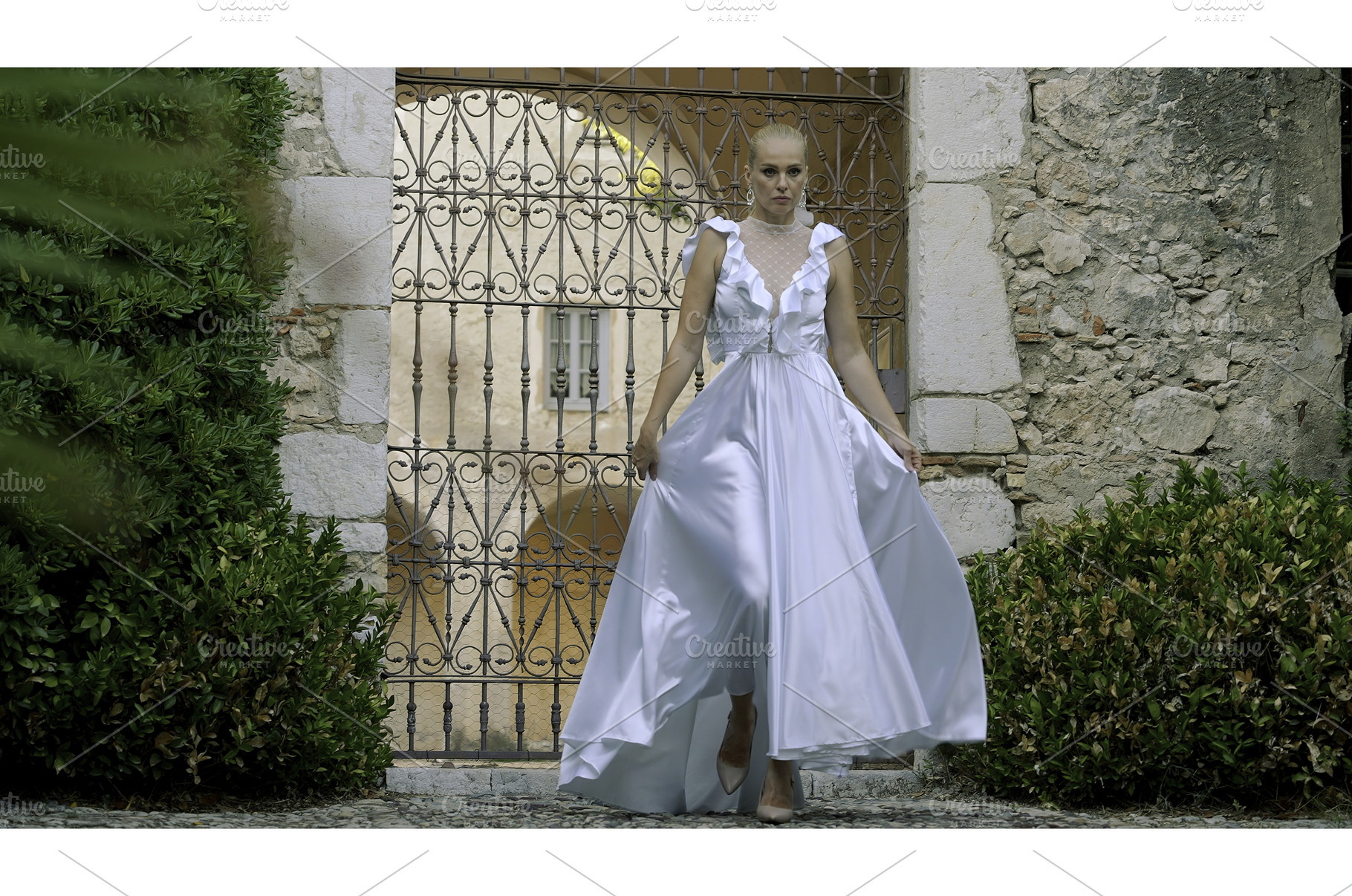 Bride walking in front of the gate, a Person Photo by Media Whale Stock