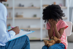 Upset little black kid crying at psychotherapy session, a Photo by Prostock-Studio