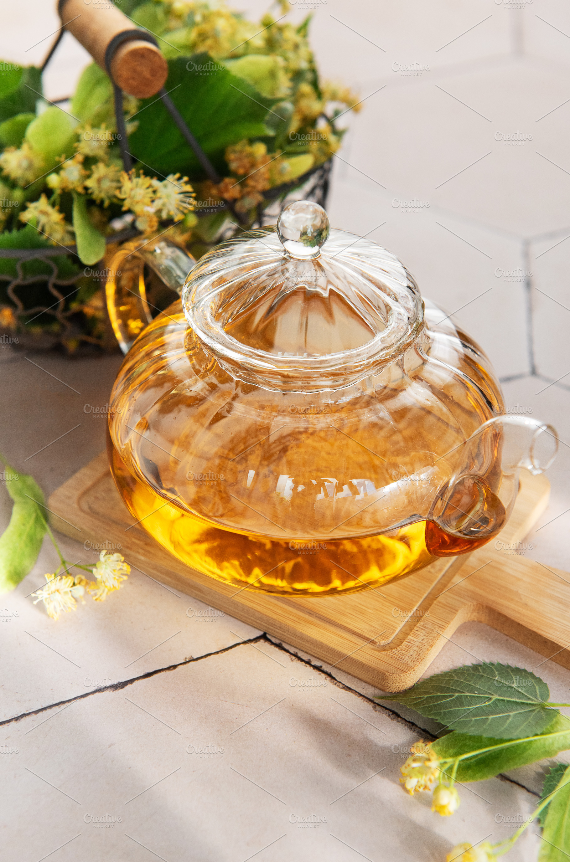 Linden tea brewing in glass teapot with lime blossom, a Food & Drink Photo by Olena Rudo