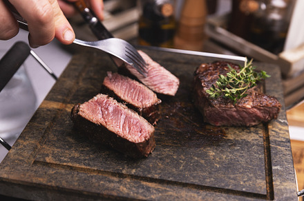 Chef cutting grilled medium rare steak, a Photo by Grafvision photography