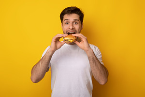 Funny Guy Holding Burger Biting Sandwich At Studio