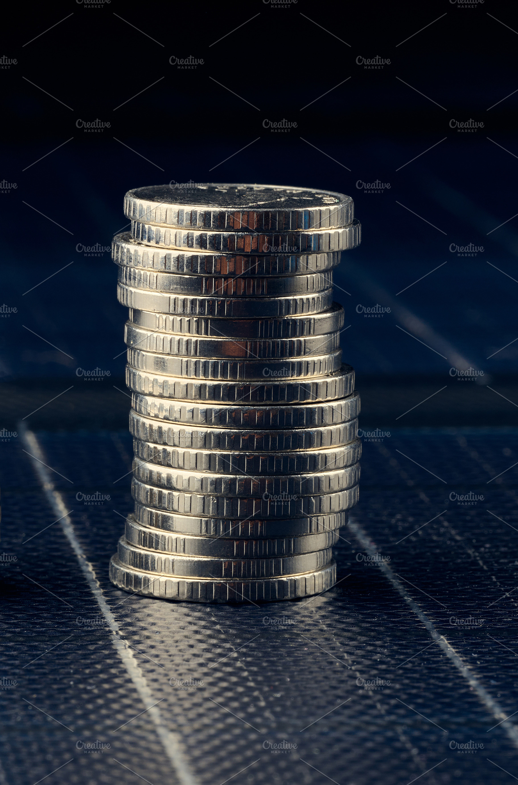 A tall stack of silver metal coins on a dark background, concept, a Business Photo by ndanko