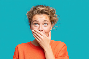 Surprised young woman covering her mouth, a Person Photo by AlyaAnd