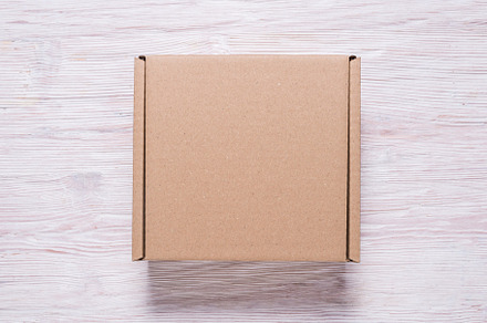 Brown carton cardboard box on wooden, a Background Photo by MDBildes