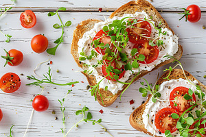 Sandwich with cream cheese, microgreens and tomatoes on wooden table, a Food & Drink Photo by AlyaAnd
