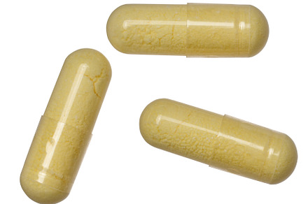 Transparent capsule with yellow powder on isolated background, m, a Health & Medical Photo by ndanko