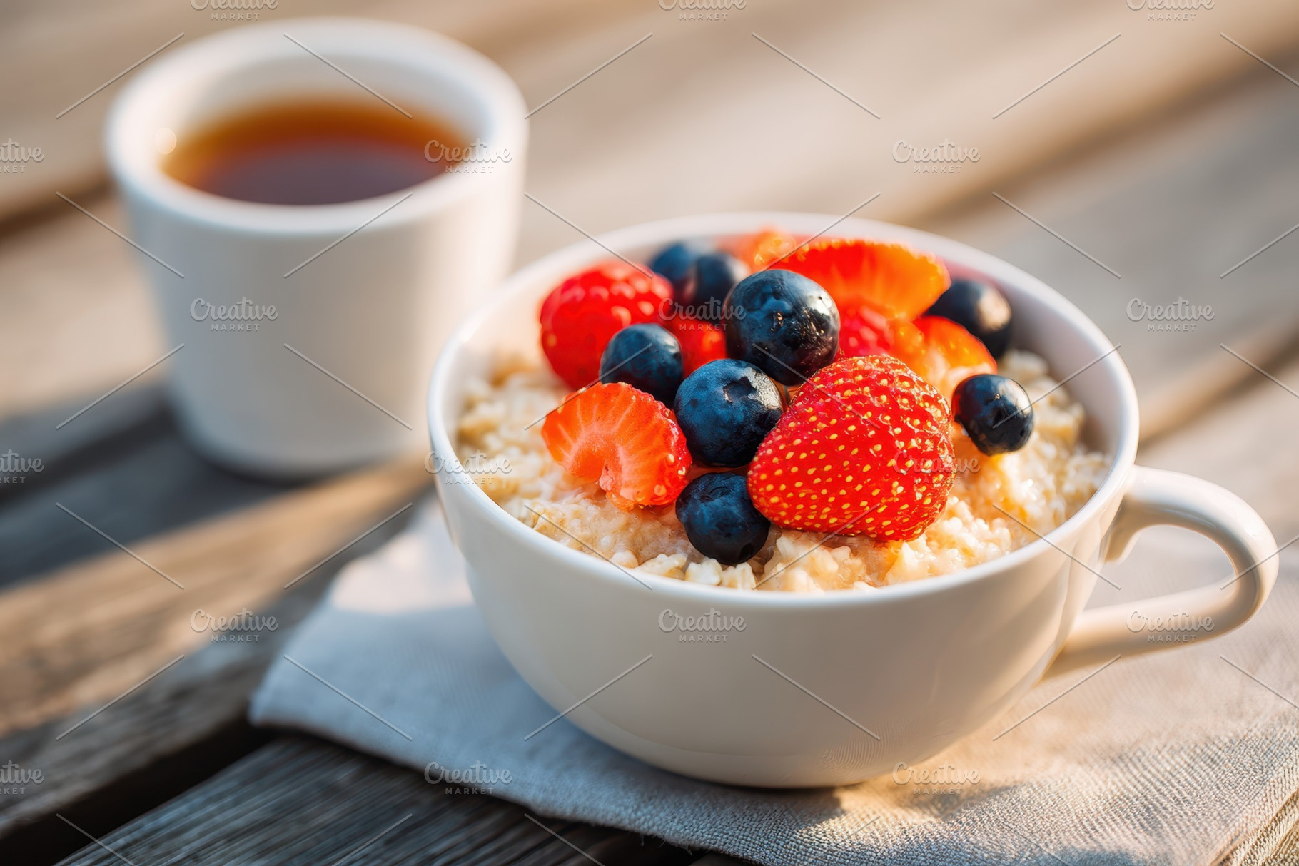 Oatmeal with berries and tea on a rustic table, a Food & Drink Photo by AlyaAnd