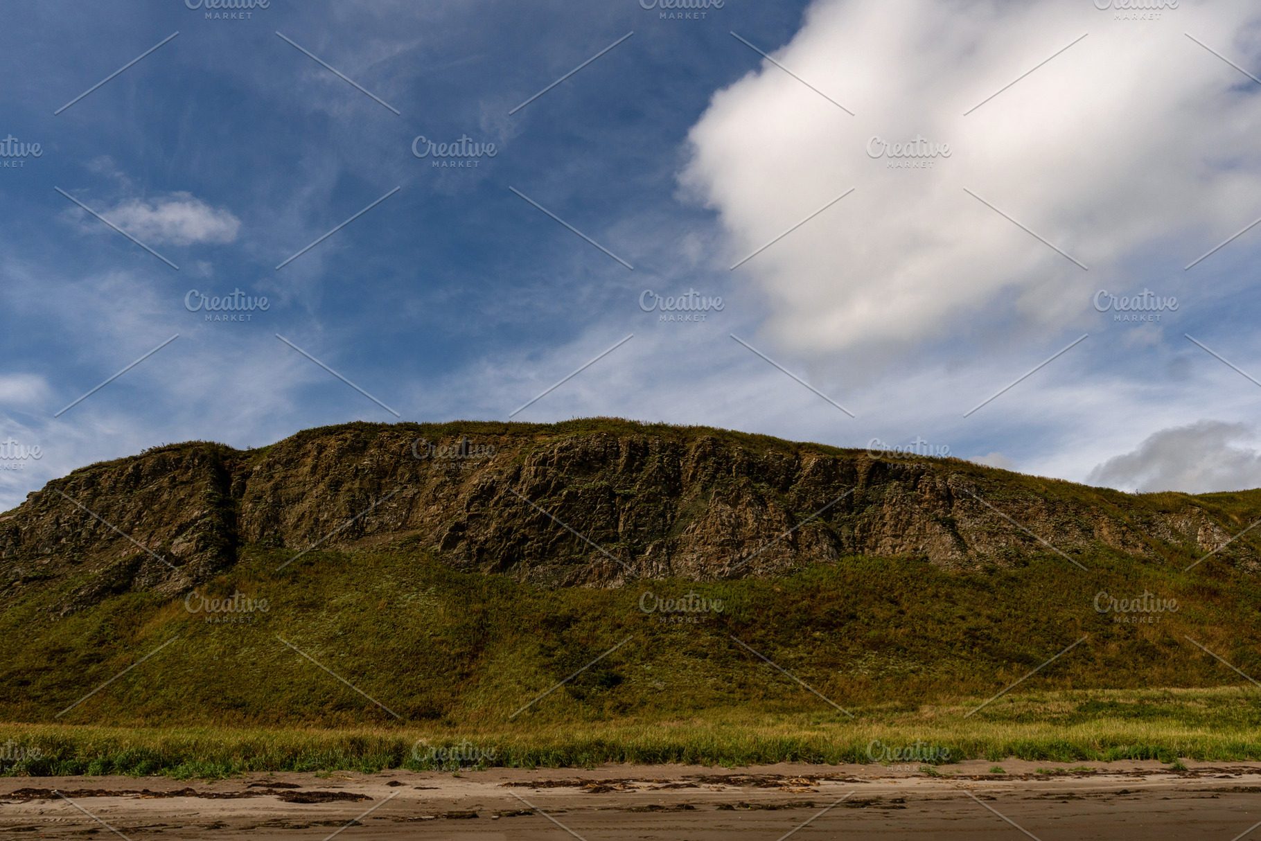 Rocky coastal cliff with grass under, a Nature Photo by Elena Vagengeim