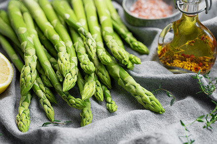 Bunch of raw asparagus stems with different spices, a Food & Drink Photo by Olena Rudo