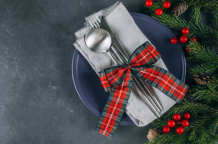 Christmas table setting on blue table. Blue plate and silver utensils. Festive, a Holiday Photo by Anikona