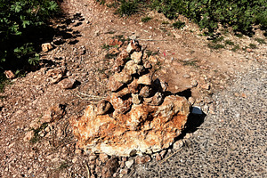 Stacked rocks formation on a trail in Nazare, Portugal under sunlight, a Photo by AS photostudio