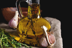 Olive oil in glass bottleon linen napkin on a dark background