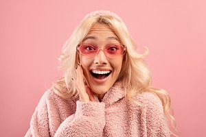 Breathtaking advertisement. Surprised stylish lady with hand on cheek looking a, a Photo by Prostock-Studio