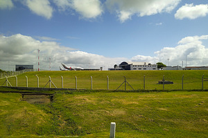 Airplane on runway under blue sky in rural airfield, a Transportation Photo by DanFLCreativo